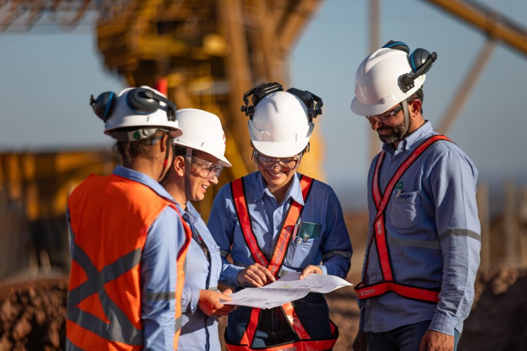 Equipe da Cardan Engenharia analisando projetos em uma área de mineração no Brasil, mostrando colaboração e uso de EPIs.